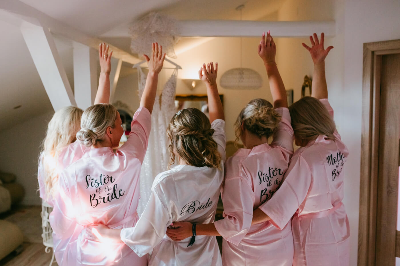 dziewczyny na przygotowaniach ślubnych trzymające ręce w górze