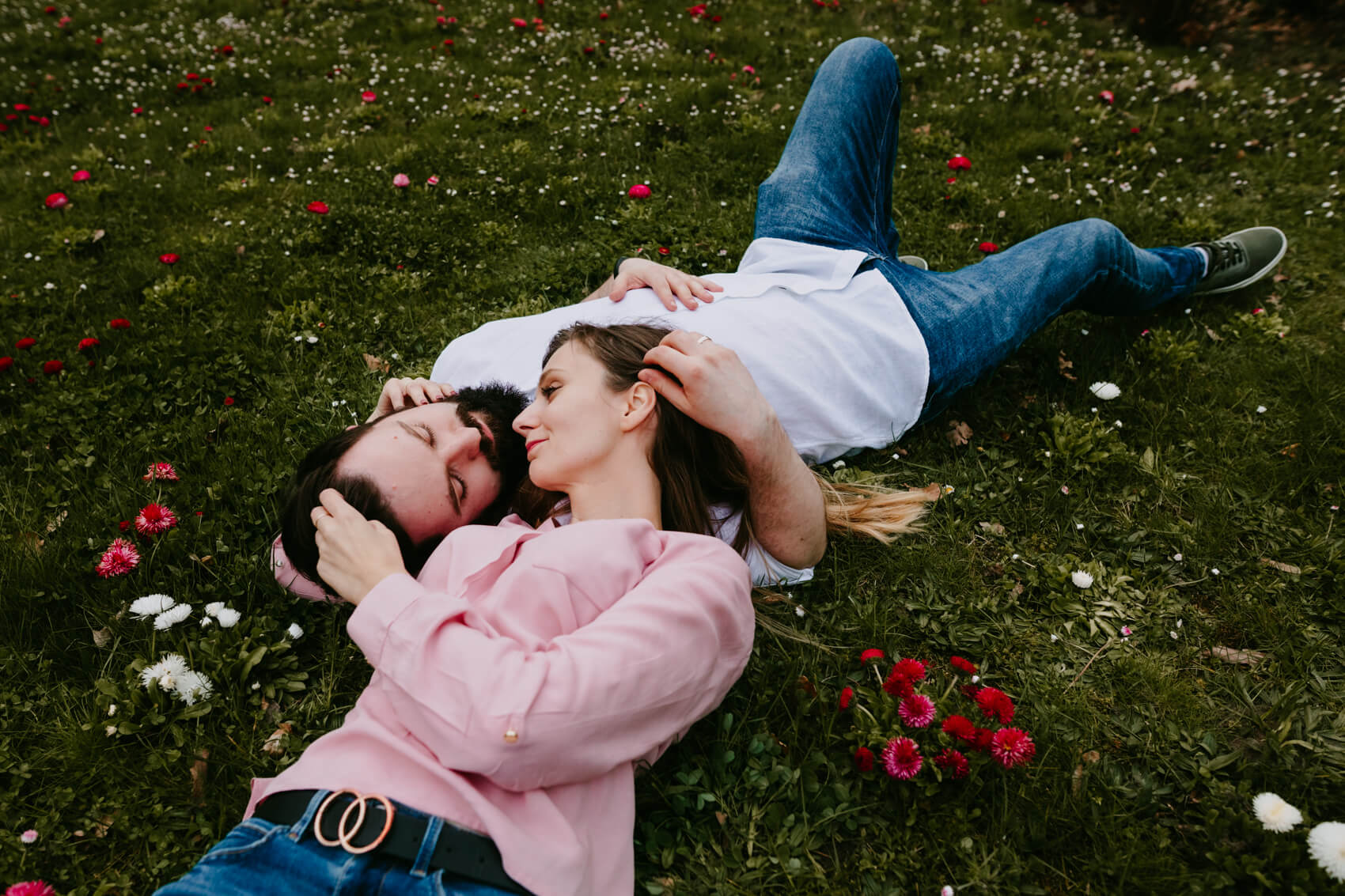 przytulająca się para leżąca na trawie